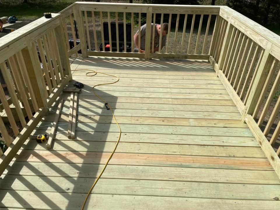 Finished pressure-treated deck with railings on a Maine property