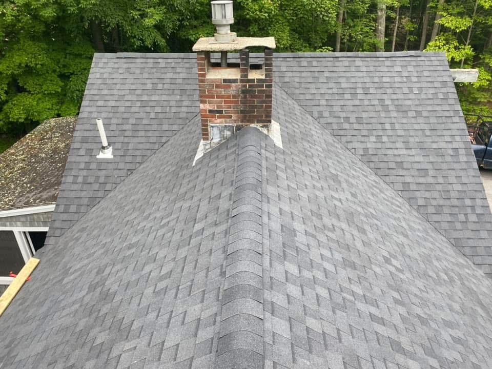 Roofing work underway on a shingled home in Southern Maine by C.B. Construction